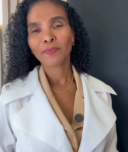 Dra. Rosana Frempong de jaleco branco, gravando vídeo educativo no consultório